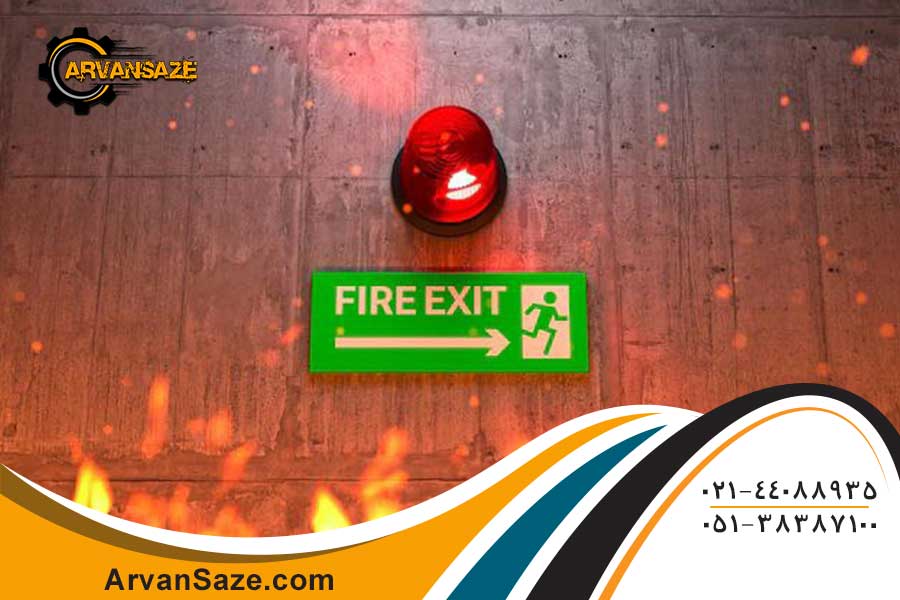 تصویری از شعله های آتش، آژیر خطری که بر روی دیوار نصب شده و علامت راه فرار برای خروج در زیر چراغ